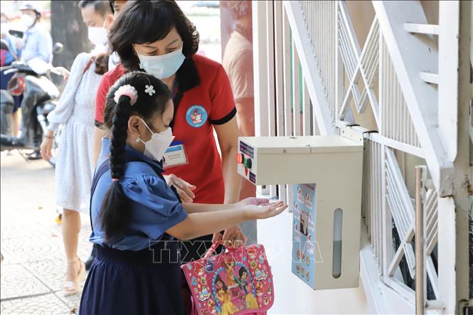Photo:  Use of alcohol-based hand sanitizers are recommended for primary students at Hoa Binh Primary School in district 1 on the first day back to school. VNA Photo: Hồng Giang