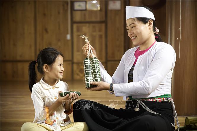 Chị Bùi Thị Chiều ở bản Giang Mỗ, xã Bình Thanh, huyện Cao Phong chia sẻ, việc cùng bố mẹ và các con ngồi gói bánh trong những ngày lễ, tết luôn mang đến cho chị niềm hạnh phúc và cũng là sự giáo dục cho các thế hệ con cháu cần phát huy và lưu giữ nét đẹp văn hoá của dân tộc. Ảnh: Trọng Đạt-TTXVN