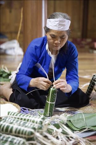 Cụ bà Đinh Thị Nhân khéo léo buộc lạt để hoàn thiện chiếc bánh ống. Gia đình cụ ở bản Giang Mỗ, xã Bình Thanh, huyện Cao Phong. Ảnh: Trọng Đạt-TTXVN