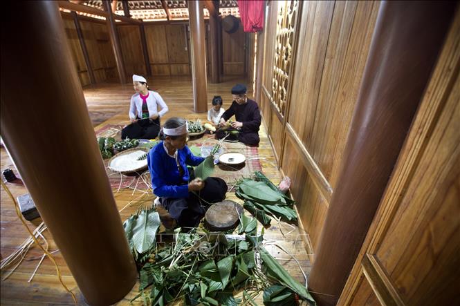 Trong không gian nhà sàn những ngày lễ tết, các thế hệ gia đình người Mường quây quần tụ họp để gói bánh chưng và bánh ống. Ảnh: Trọng Đạt-TTXVN