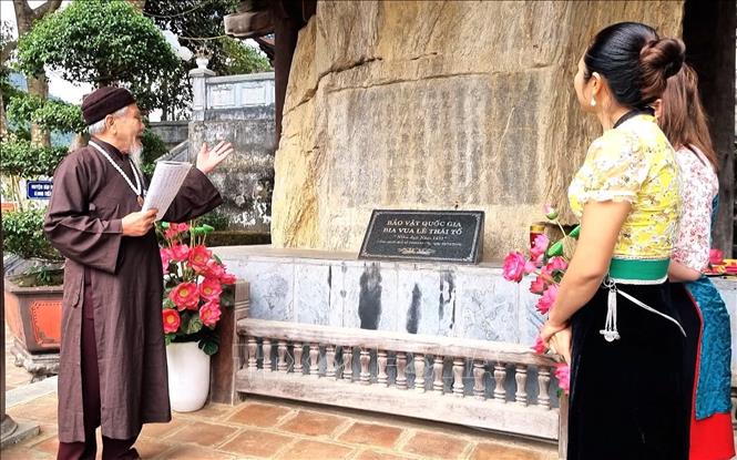 Trong ảnh: Thủ nhang Vũ Phong Oanh, ở xã Lê Lợi, huyện Nậm Nhùn giới thiệu cho du khách về bảo vật quốc gia Bia Lê Thái Tổ. Ảnh: Nguyễn Oanh-TTXVN
