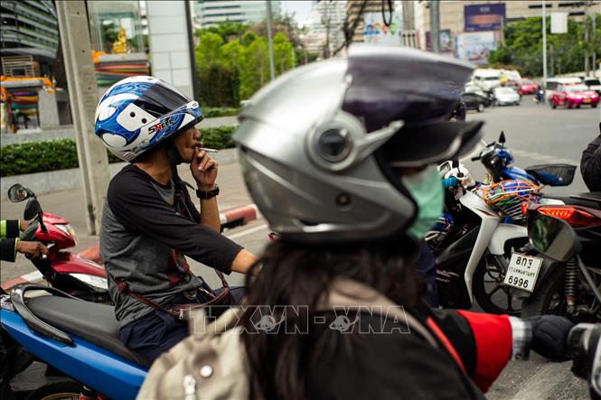 Trong ảnh (tư liệu): Người dân hút thuốc lá khi dừng đèn đỏ tại Bangkok, Thái Lan. Ảnh: AFP/TTXVN