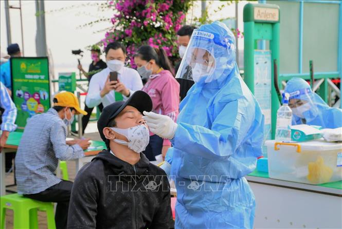 Xét nghiệm Covid-19 cho hành khách trước khi lên tàu. Ảnh: TTXVN phát