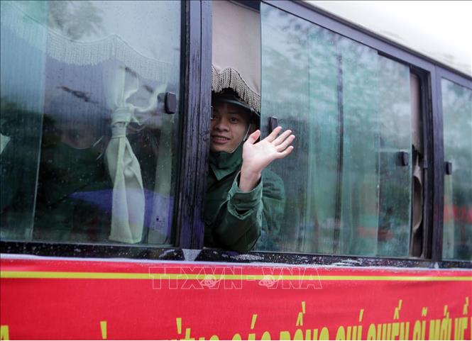 Tân binh vẫy tay chào người thân, lên đường nhập ngũ. Ảnh: Quý Trung – TTXVN