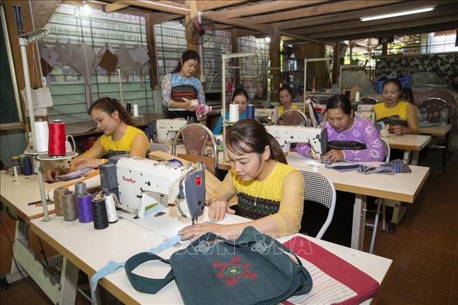Trong ảnh: Các hội viên Hợp tác xã dệt thổ cẩm và dịch vụ Chiềng Châu sản xuất các sản phẩm từ vải thổ cẩm. Ảnh: Trọng Đạt - TTXVN