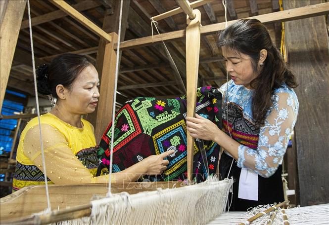 Trong ảnh: Chị Vì Thị Oanh (áo xanh), Phó Chủ nhiệm Hợp tác xã dệt thổ cẩm và dịch vụ du lịch Chiềng Châu chia sẻ kinh nghiệm cho các hội viên. Ảnh: Trọng Đạt - TTXVN