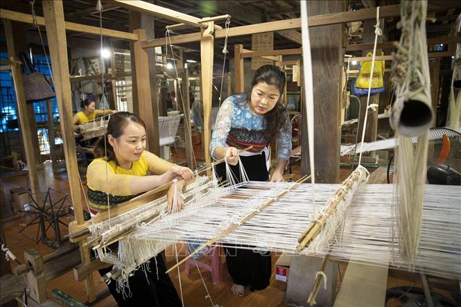 Trong ảnh: Chị Vì Thị Oanh (áo xanh), Phó Chủ nhiệm Hợp tác xã dệt thổ cẩm và dịch vụ du lịch Chiềng Châu, huyện Mai Châu (Hòa Bình) hướng dẫn kỹ thuật dệt thổ cẩm cho hội viên. Ảnh: Trọng Đạt - TTXVN