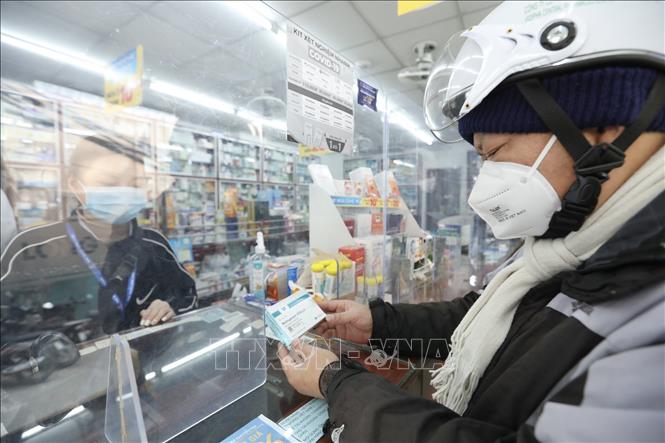 Người dân đến tìm hiểu và mua thuốc Molnupiravir điều trị COVID-19 tại cửa hàng thuốc Long Châu (Hà Nội). Ảnh: Minh Quyết - TTXVN