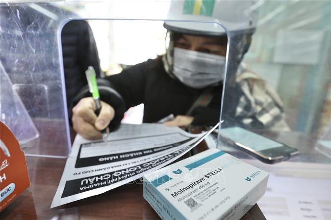 Khi mua thuốc Molnupiravir điều trị COVID-19 tại cửa hàng thuốc Long Châu (Hà Nội), khách hàng cần xác nhận thông tin mua thuốc tại đây. Ảnh: Minh Quyết - TTXVN
