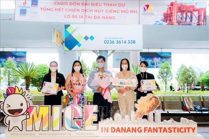 Trong ảnh: Đại diện đoàn khách MICE được tặng hoa và quà tại lễ đón. Ảnh: TTXVN phát