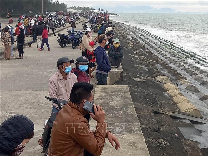 Người dân theo dõi lực lượng chức năng tìm kiếm nạn nhân mất tích tại Cửa Đại. Ảnh: TTXVN