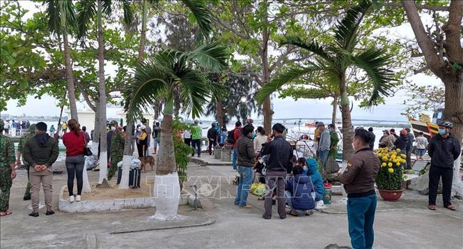 Người dân theo dõi lực lượng chức năng tìm kiếm nạn nhân mất tích tại Cửa Đại. Ảnh: TTXVN