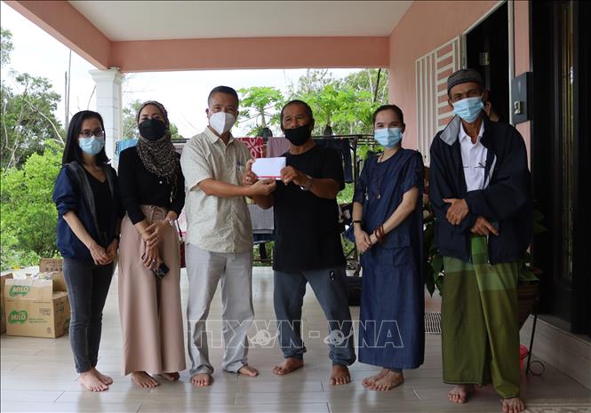 Tham tán Đại sứ quán Việt Nam tại Malaysia Nguyễn Hồng Sơn và đại diện một số nhóm từ thiện trao quà cho đại diện cộng đồng người Chăm tại Charating, bang Pahang. Ảnh: Mạnh Tuân - PV TTXVN tại Malaysia