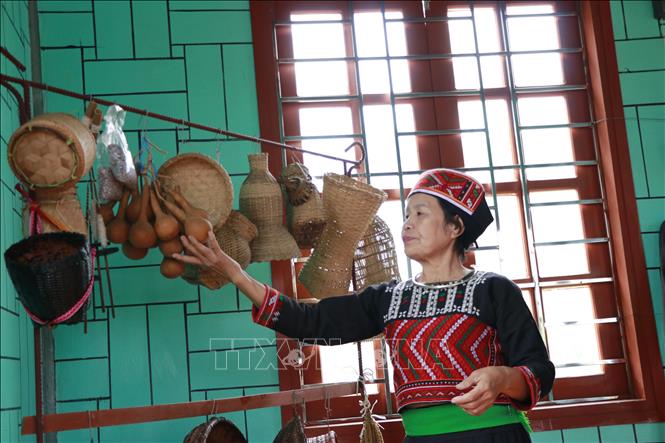 Nghệ nhân Đặng Thị Thanh giới thiệu về các vật dụng sinh hoạt của người Phù Lá. Ảnh: Việt Dũng - TTXVN