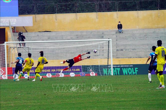 Pha bay người cứu thua của thủ môn Văn Hoàng (áo cam) đội Sông Lam Nghệ An. Ảnh: Tá Chuyên - TTXVVN