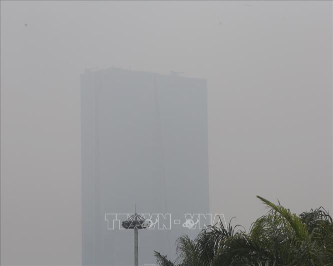 Các toà nhà cao tầng gần như bị che kín bởi lớp sương mù dày đặc. Ảnh: Tuấn Đức - TTXVN