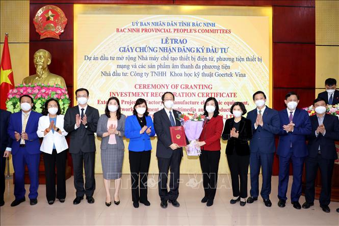 Trong ảnh: Lãnh đạo tỉnh Bắc Ninh tặng hoa chúc mừng Công ty Goertek Vina được trao Giấy chứng nhận đầu tư mở rộng. Ảnh: Đinh Văn Nhiều-TTXVN