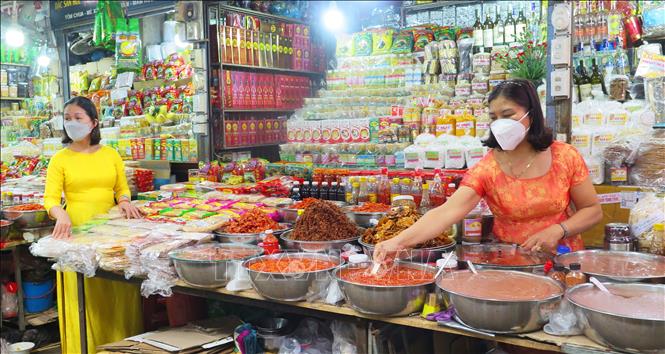 Trong ảnh: Tiểu thương chợ Đông Ba mặc áo dài buôn bán góp phần làm đẹp hơn hình ảnh ngôi chợ truyền thống hơn 120 tuổi. Ảnh: Tường Vi - TTXVN