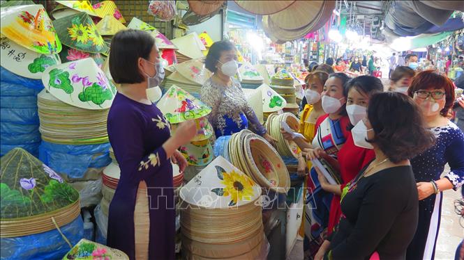 Trong ảnh: Tiểu thương chợ Đông Ba mặc áo dài buôn bán góp phần làm đẹp hơn hình ảnh ngôi chợ truyền thống hơn 120 tuổi. Ảnh: Tường Vi - TTXVN