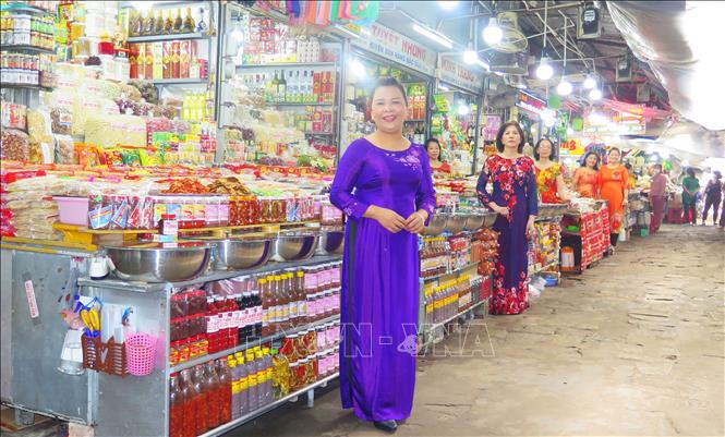 Trong ảnh: Tiểu thương chợ Đông Ba mặc áo dài buôn bán góp phần làm đẹp hơn hình ảnh ngôi chợ truyền thống hơn 120 tuổi. Ảnh: Tường Vi - TTXVN
