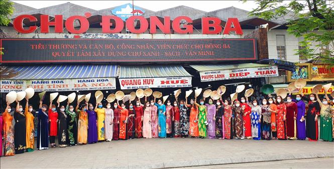 Trong ảnh: Những ngày đầu tháng 3 chợ Đông Ba trở nên tươi mới, sắc màu với những tà áo dài thướt tha. Ảnh: Tường Vi - TTXVN

