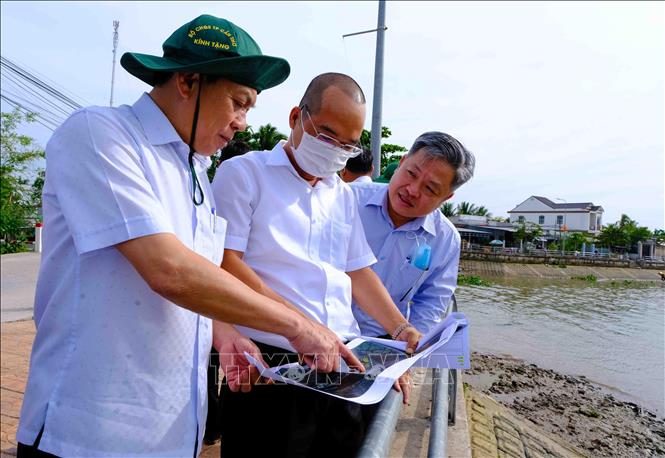 Phó Chủ tịch UBND thành phố Cần Thơ Nguyễn Ngọc Hè (trái) xem sơ đồ vị trí các tuyến kè đang xây dựng trên sông Ô Môn. Ảnh: Thanh Liêm - TTXVN