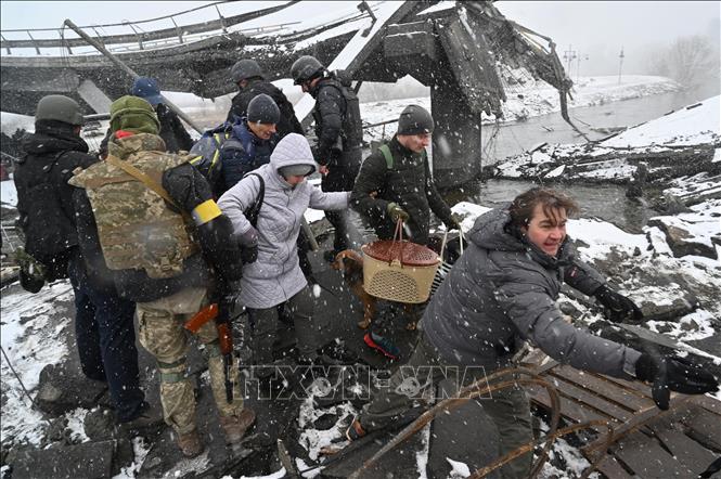 Trong ảnh: Binh sĩ Ukraine hỗ trợ người sơ tán khỏi thành phố Irpin, phía Tây Bắc thủ đô Kiev ngày 8/3/2022. Ảnh: AFP/TTXVN