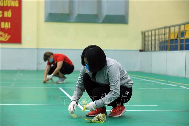 Trong ảnh: Các băng keo dính được bóc tách khỏi sàn thi đấu để đảm bảo an toàn, sạch đẹp. Ảnh: Tuấn Anh - TTXVN