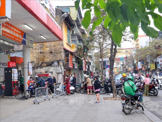 Người dân xếp hàng tràn ra cả lòng đường tại trạm xăng phố Khâm Thiên. Ảnh: Tuấn Đức - TTXVN