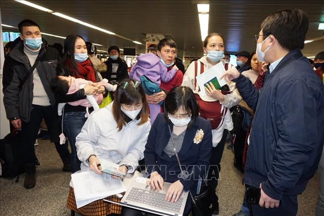 Photo: The staff of the Vietnamese Embassy in Poland assist Vietnamese expats to complete procedures before getting on board on a repatriation flight on March 9. VNA Photo: Hồng Kỳ