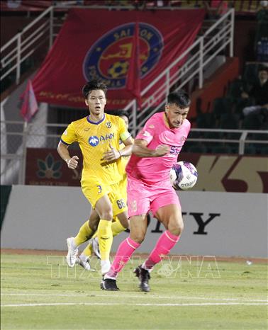 Trong ảnh: Pha tranh bóng giữa các cầu thủ giữa đội chủ nhà Sài Gòn FC (áo hồng) và đội Sông Lam Nghệ An (áo vàng). Ảnh: Thanh Vũ-TTXVN
