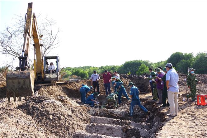 Đội tìm kiếm tiến hành quy tập hài cốt liệt sĩ. Ảnh: TTXVN phát