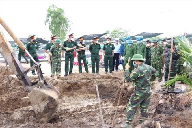 Đội tìm kiếm tiến hành quy tập hài cốt liệt sĩ. Ảnh: TTXVN phát