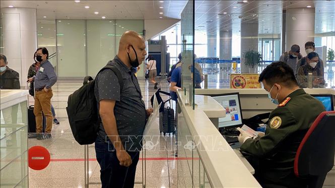 Passengers conduct entry procedures at Noi Bai International Airport on the first day of reopening to international arrivals. VNA Photo