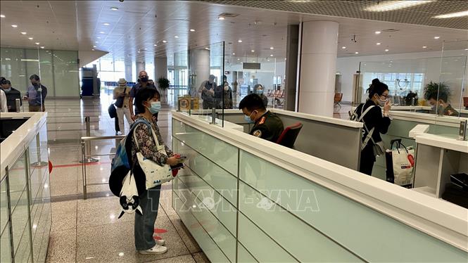 Passengers conduct entry procedures at Noi Bai International Airport on the first day of reopening to international arrivals. VNA Photo