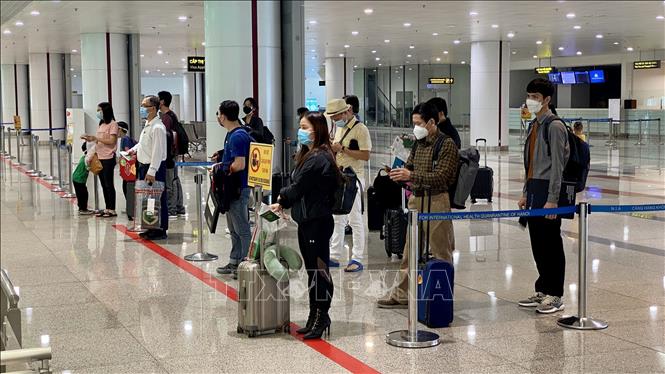 Passengers conduct entry procedures at Noi Bai International Airport on the first day of reopening to international arrivals. VNA Photo