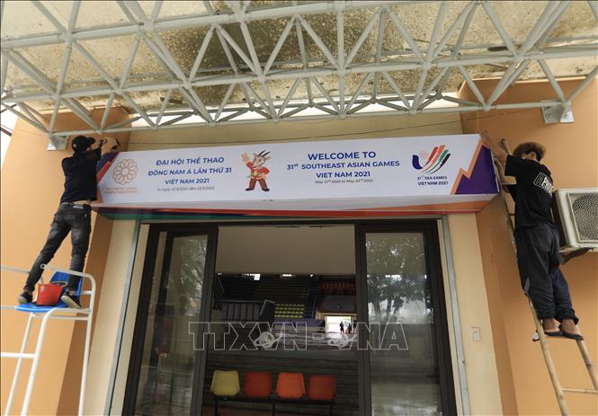 Trong ảnh: Công nhân thi công hoàn thiện các tấm pano cổ vũ cho bộ môn Bóng rổ SEA Games 31 tại Nhà thi đấu Thanh Trì. Ảnh: Hoàng Hiếu - TTXVN