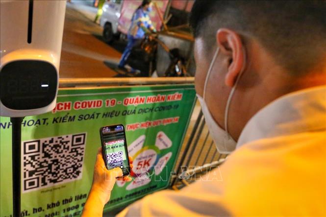 Người dân quét mã QR trước kho vào phố đi bộ. Ảnh: Tuấn Đức - TTXVN