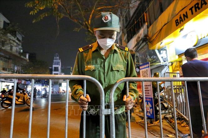 Lực lượng chức năng dựng hàng rào tại một điểm chốt vào phố đi bộ. Ảnh: Tuấn Đức - TTXVN