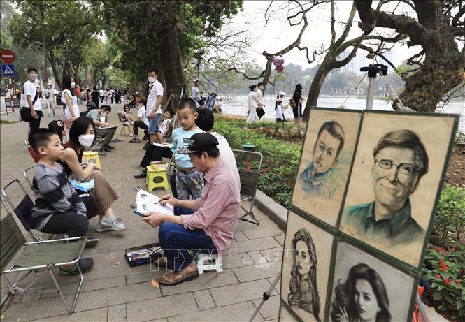 Khu vực ký họa chân dung trên phố đi bộ khu vực Hồ Gươm thu hút nhiều người dân. Ảnh: Hoàng Hiếu - TTXVN 