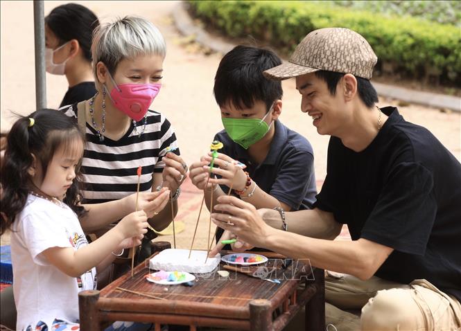 Gia đình anh Tường Ninh cùng nhau tham gia trò chơi dân gian nặn tò he tại phố đi bộ Hồ Gươm. Ảnh: Hoàng Hiếu - TTXVN 