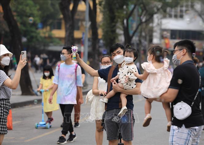 Nhiều gia đình đến phố đi bộ khu vực Hồ Gươm để vui chơi sáng 20/3. Ảnh: Hoàng Hiếu - TTXVN 
