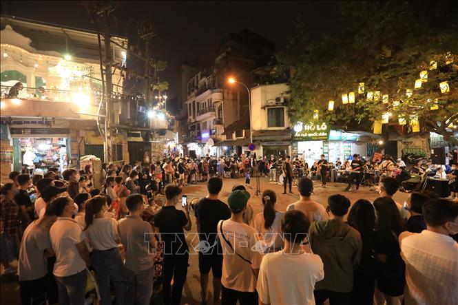 Trong ảnh: Biểu diễn văn nghệ tại ngã tư phố Đinh Liệt và Gia Ngư thu hút đông đảo người dân và khách du lịch. Ảnh: Hoàng Hiếu - TTXVN 