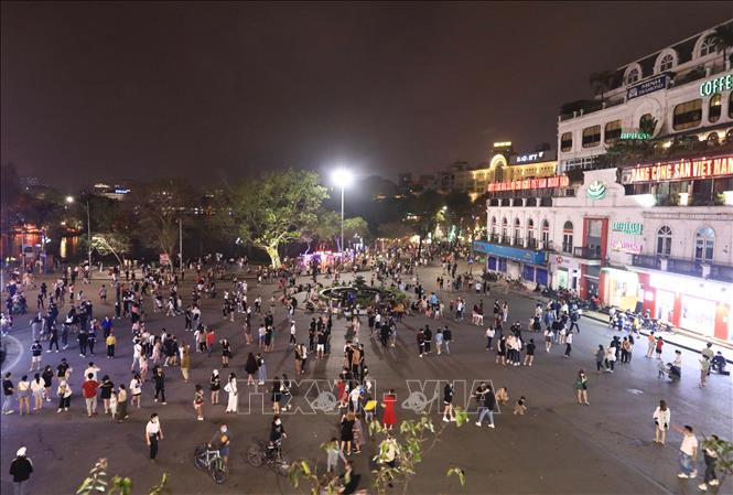 Trong ảnh: Đông đảo người dân đến vui chơi trên tuyến phố đi bộ khu vực Hồ Gươm tối 20/3. Ảnh: Hoàng Hiếu - TTXVN 