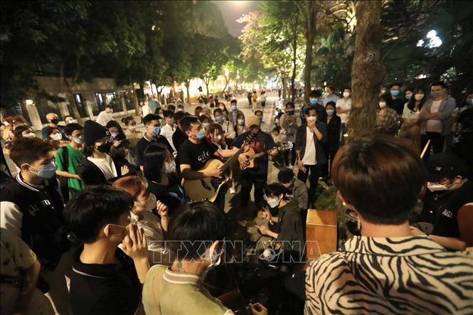 Trong ảnh: Các bạn trẻ tập trung thưởng thức một tiết mục văn nghệ biểu diễn trên tuyến phố đi bộ Hồ Gươm, tối 20/3. Ảnh: Hoàng Hiếu - TTXVN 