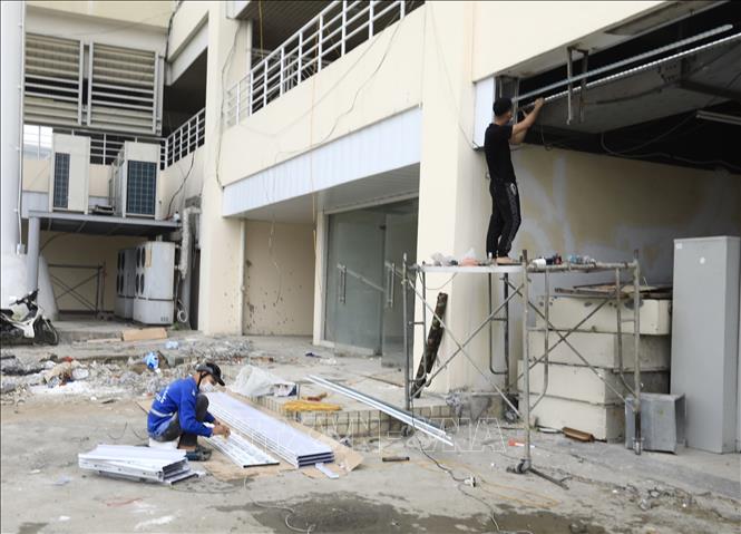 Trong ảnh: Công nhân đang khẩn trương thi công, sửa chữa mặt ngoài của Sân vận động Mỹ Đình. Ảnh: Hoàng Hiếu – TTXVN