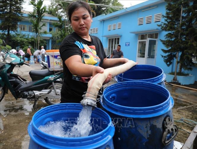 Người dân dùng mọi vật liệu để lấy nước sinh hoạt tại Nhà máy nước Hạ Đình (Hà Nội). Ảnh: Thành Đạt - TTXVN