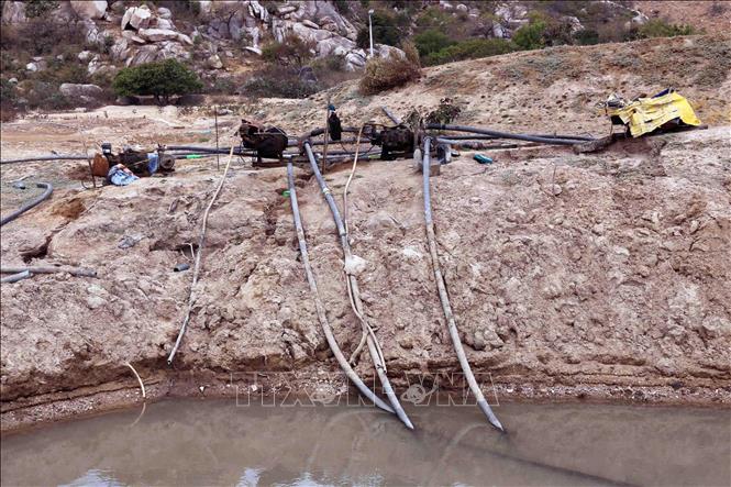 Tỉnh Ninh Thuận triển khai nhiều giải pháp cấp bách để quản lý nguồn nước ở các hồ chứa hiện có, phục vụ nhu cầu cấp thiết trong mùa hạn, trong đó lắp đặt máy bơm để khai thác nước ngầm tại ao chống hạn, đưa nước tưới cho cây trồng. Ảnh: Công Thử - TTXVN