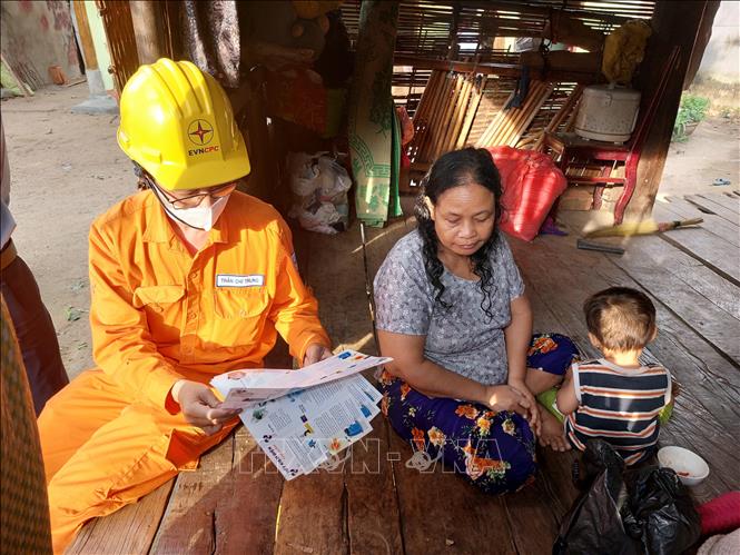 Công nhân Công ty Điện lực Kon Tum tuyên truyền, phát tờ rơi tại làng Kon Ktu (xã Đăk Rơ Wa, thành phố Kon Tum) nhằm nâng cao nhận thức của người đồng bào dân tộc thiểu số về tiết kiệm điện. Ảnh: Khoa Chương - TTXVN