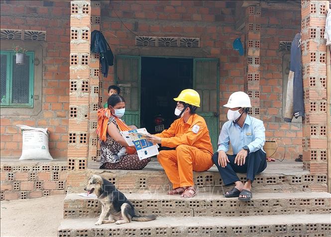 Công nhân Công ty Điện lực Kon Tum tuyên truyền, phát tờ rơi tại làng Kon Ktu (xã Đăk Rơ Wa, thành phố Kon Tum) nhằm nâng cao nhận thức của người đồng bào dân tộc thiểu số về tiết kiệm điện. Ảnh: Khoa Chương - TTXVN